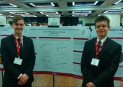 Picture of students presenting research poster at conference